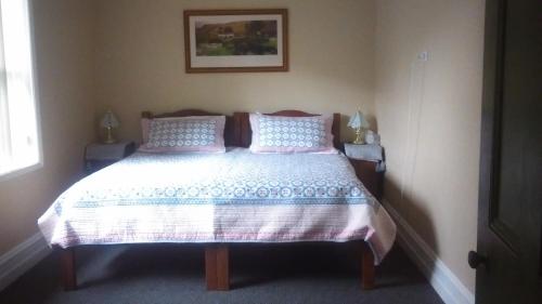 a bedroom with a bed with pink and blue pillows at Grampians Historic Homestead B&B in Moutajup