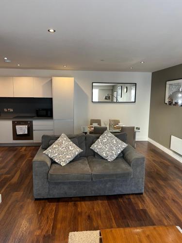 a living room with a couch and a kitchen at Stunning Manchester City Centre Apartment! Ideal for small groups in Manchester