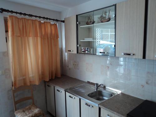 a small kitchen with a sink and a mirror at Apartments Lička 25 in Split
