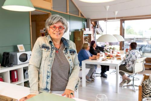 an older woman is standing in a room at StroEnzo - RUIME LOFT - 5P - 2SLPK - DAKTERRAS - LAADPAAL - 10MIN Maastricht in Riemst