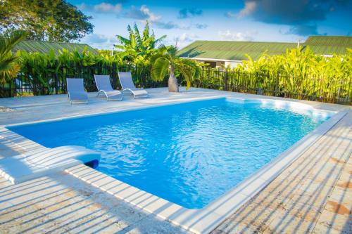 a swimming pool with lounge chairs and a swimming pool at Les Bungalows du Moulin in Saint-François