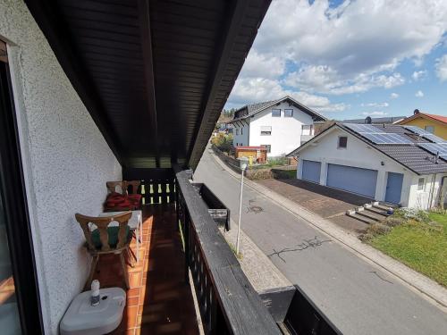 a balcony with a bench and a view of a street at Ferienwohnung am Sonnenberg in Hammelbach