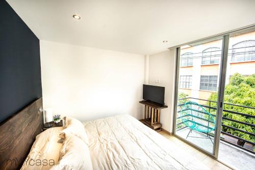 um quarto com uma cama e uma grande janela em Bright Stylish Apartment Near Polanco em Cidade do México