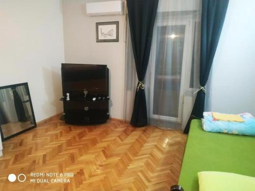 a living room with a television and a wooden floor at Villa Old Town in Podgorica