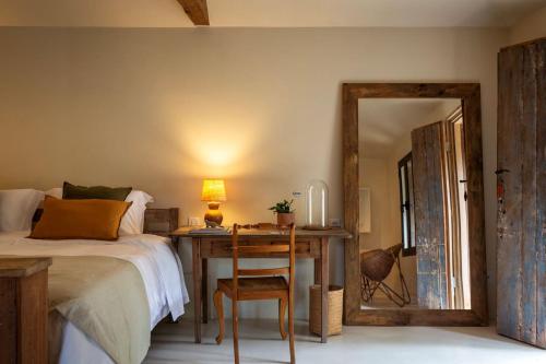 a bedroom with a bed and a desk and a mirror at Na Praça Hotel in Trancoso