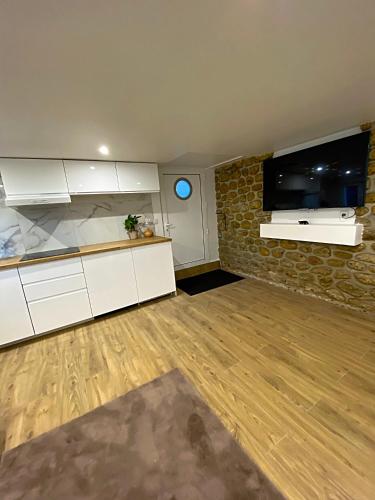 uma sala de estar com armários brancos e uma televisão de ecrã plano em Appartement neuf paisible proche aéroport em Morangis
