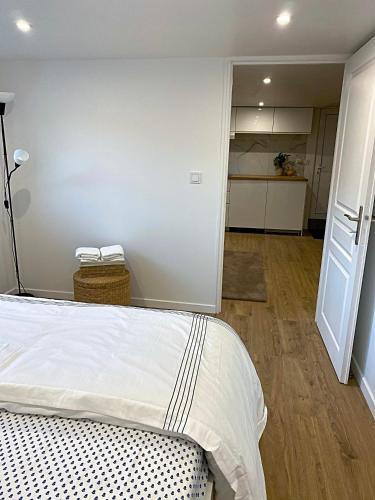 een slaapkamer met een bed en een kamer met een keuken bij Appartement neuf paisible proche aéroport in Morangis