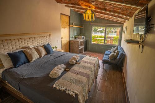 1 dormitorio con 1 cama grande y 1 sofá en roca azul cabañas sa de cv, en Jocotepec