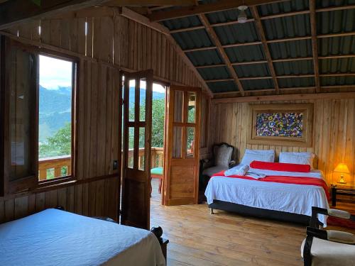 a bedroom with two beds and a large window at Oro Verde Noche De Luna in Jardin