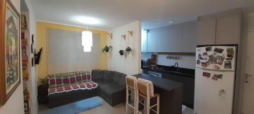 a living room with a couch and a kitchen at Apartamento aconchegante em Itajaí in Itajaí