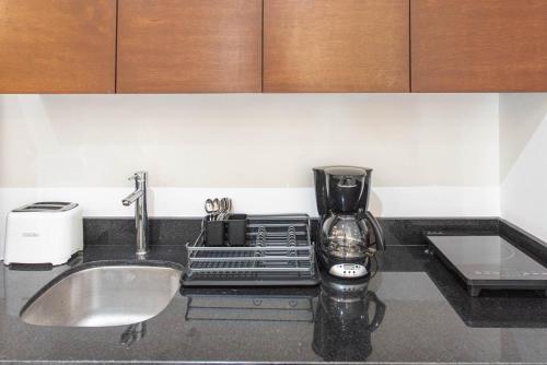 a kitchen counter with a mixer and a sink at CondoHotel Piedra del Caribe in Puerto Morelos