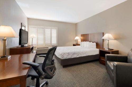 a hotel room with a bed and a desk and a chair at Best Western Lanai Garden Inn & Suites in San Jose