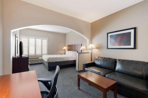 Best Western Lanai Garden Inn & Suites في سان خوسيه: غرفة معيشة مع أريكة وسرير