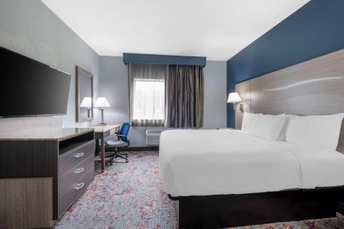a hotel room with a large bed and a desk at Best Western Kokomo Hotel in Kokomo