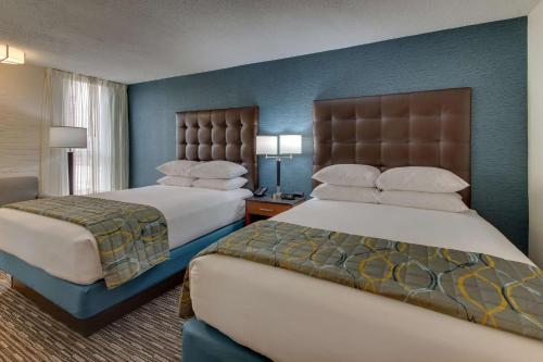 duas camas num quarto de hotel com paredes azuis em Pear Tree Inn St. Louis Airport em Edmundson