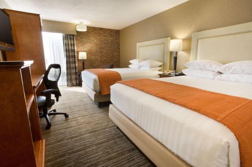 a hotel room with two beds and a desk at Drury Inn & Suites Austin North in Austin