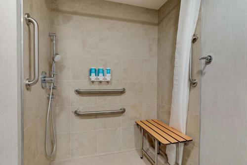 a shower with a wooden bench in a bathroom at Drury Inn & Suites Atlanta Marietta in Marietta