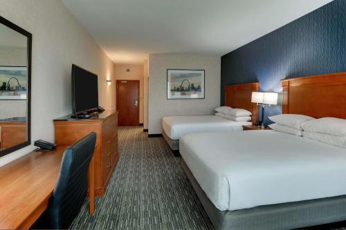 a hotel room with two beds and a television at Drury Inn & Suites St. Louis Arnold in Arnold