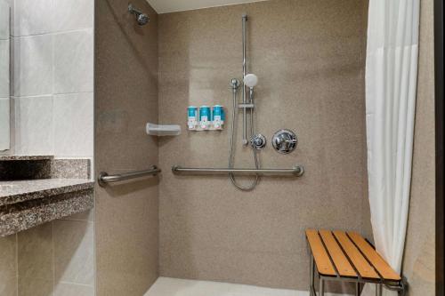 a shower with a wooden bench in a bathroom at Drury Inn & Suites Columbus Dublin in Dublin