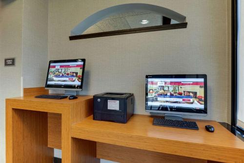 a desk with two computer monitors and a printer at Drury Inn & Suites Columbus Dublin in Dublin