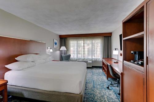 a hotel room with a large bed and a desk at Drury Inn & Suites San Antonio Airport in San Antonio