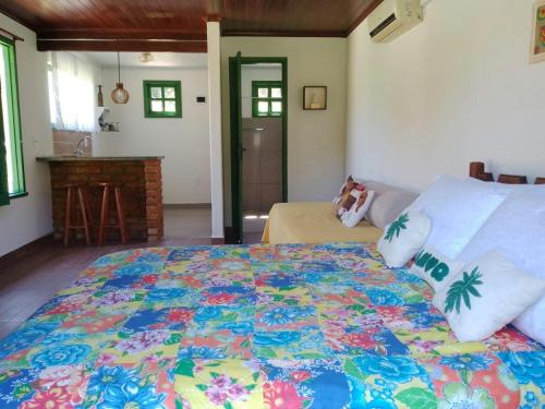 1 dormitorio con 1 cama con colcha colorida en Pouso Jambo Rosa, en Valença