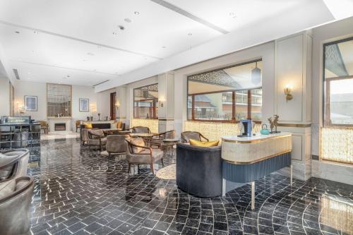 a lobby with a bar and tables and chairs at Radisson Collection Hotel & Spa, Riverfront Srinagar in Srinagar