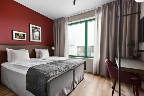 um quarto com uma cama, uma secretária e uma janela em Best Western Plus Hotel Kungens Kurva em Estocolmo