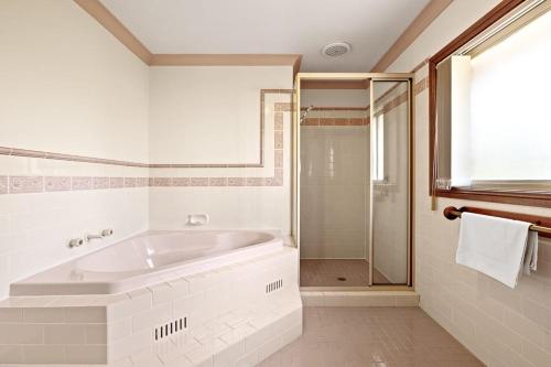 a white bathroom with a tub and a shower at Queen Room in Gordon near Train & Bus Sleep 2 in Pymble