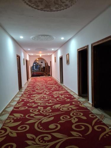 a hallway with a red carpet in a building at Hôtel et Restaurant ARIJ in Midelt
