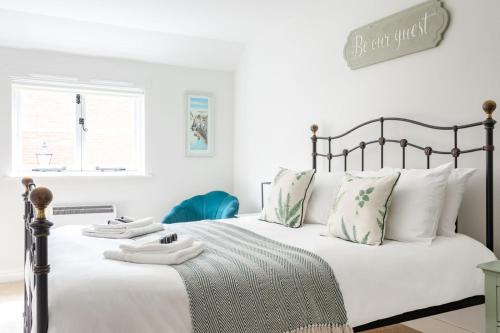 a white bedroom with a large bed with white pillows at Maldon Executive Apartments in Maldon
