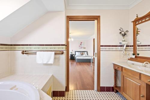 a bathroom with a tub and a sink and a mirror at Quadruple Room w Ensuite in Gordon near Train & Bus in Pymble