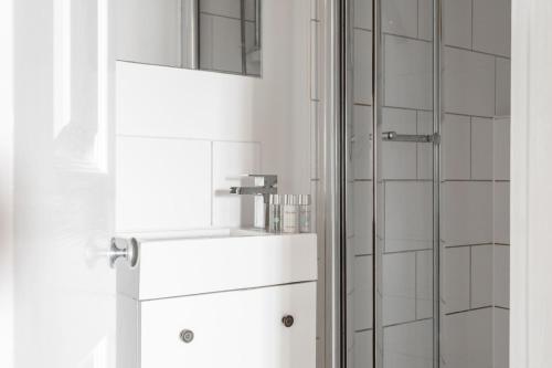 a bathroom with a shower and a white refrigerator at Maldon Executive Apartments in Maldon