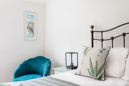 a bedroom with a bed and a blue chair at Maldon Executive Apartments in Maldon