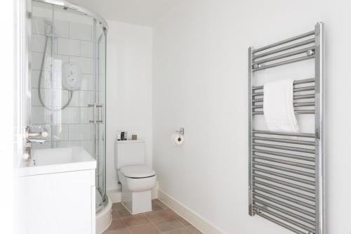 a white bathroom with a toilet and a sink at Maldon Executive Apartments in Maldon