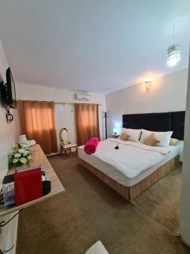a large bedroom with a large bed and a television at Hôtel et Restaurant ARIJ in Midelt