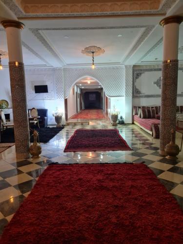 a large lobby with red carpets on the floor at Hôtel et Restaurant ARIJ in Midelt
