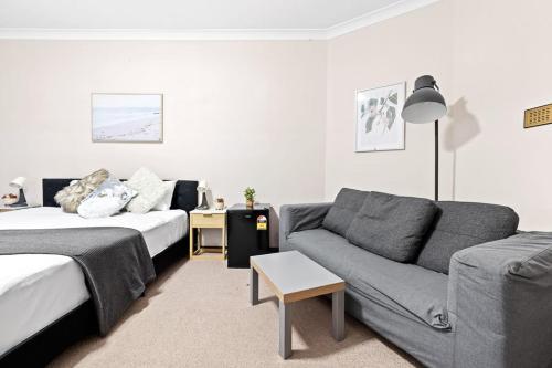 a living room with a couch and a couch and a living room at King-size Bedroom in Gordon near Train & Bus in Pymble