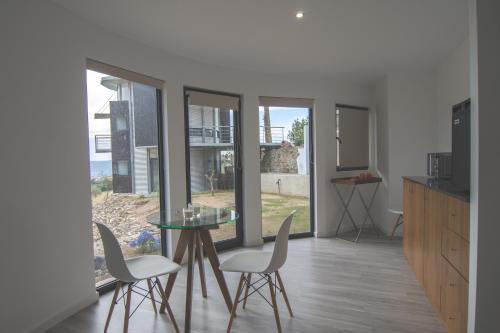 a kitchen with a glass table and white chairs at Bela Vista Silo Housing in Alfândega da Fé