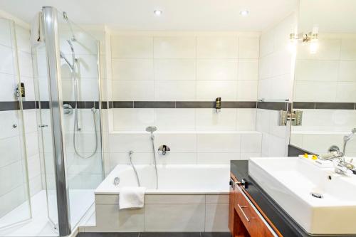 DAS WESEL - DEIN HOTEL AM RHEIN في أوبرفيزل: حمام مع دش وحوض استحمام ومغسلة