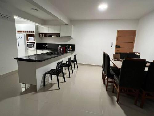 a kitchen and dining room with a table and chairs at Apartamento encantador próximo a Praia Brava in Matinhos