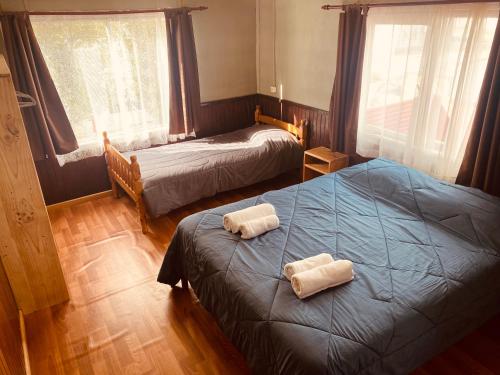 1 dormitorio con 2 camas y toallas. en HOSTAL MIRAFLORES, en Puerto Natales