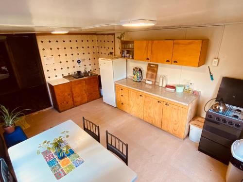 a small kitchen with a table and a refrigerator at HOSTAL MIRAFLORES in Puerto Natales