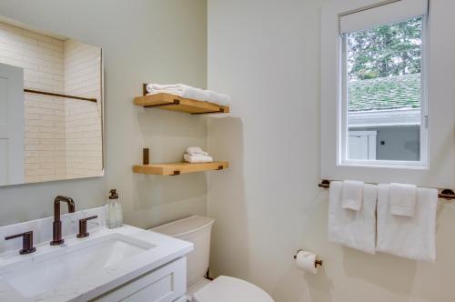 een badkamer met een wastafel, een toilet en een raam bij Modern Vacation Rental in Kirkland with Backyard! in Kirkland