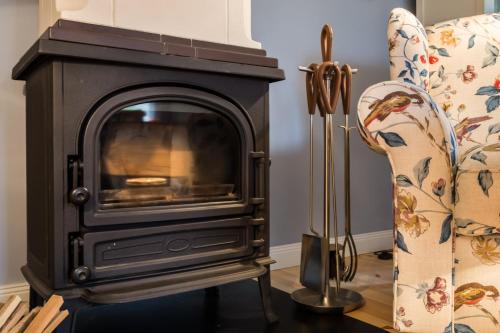 a wood stove in a living room next to a couch at Bodderkuul in Böel