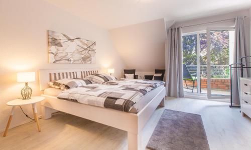 1 dormitorio con 1 cama grande y balcón en Zwischen den Stränden en Dörphof
