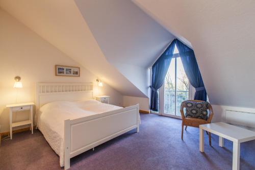 Un dormitorio con una cama y una silla y una ventana. en Ellerüher Weg Maisonette, en Kappeln