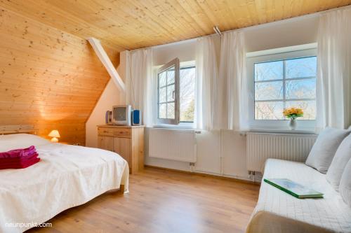 a bedroom with a white bed and two windows at Falshöft 1a in Nieby