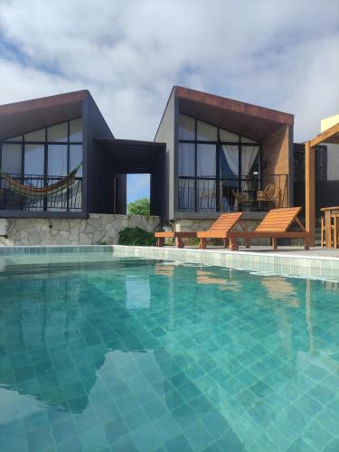 une grande piscine en face d'une maison dans l'établissement CHALE VILAALICE, à Monte das Gameleiras