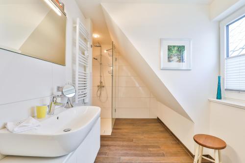 a white bathroom with a sink and a staircase at Klar zur Wende in Kappeln